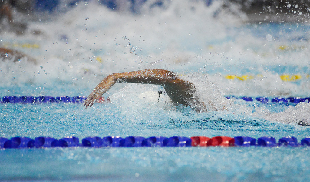 Detail photograph of a swimmer's arms during training.