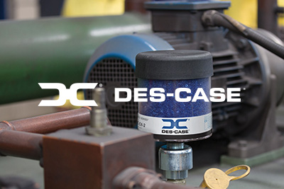 The Des-Case logo in white with machinery in the background.