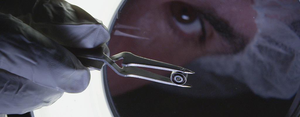 Photograph of a precision bearing being examined with a magnifier.