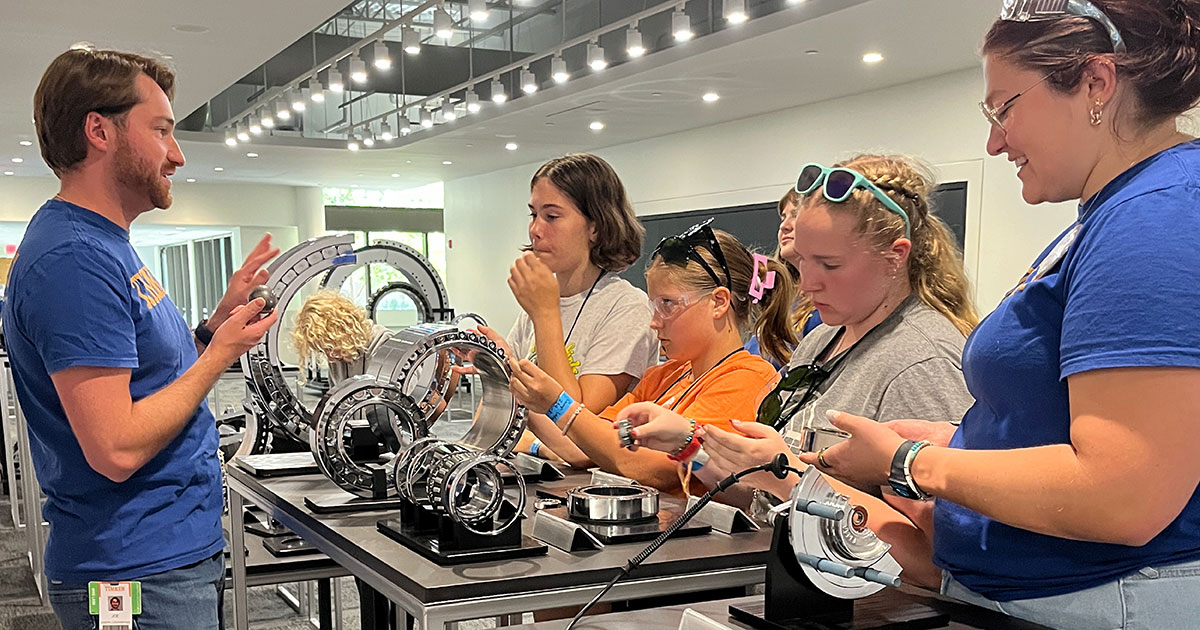 Timken volunteers showcase a variety of Timken bearings to a group of girl scouts.